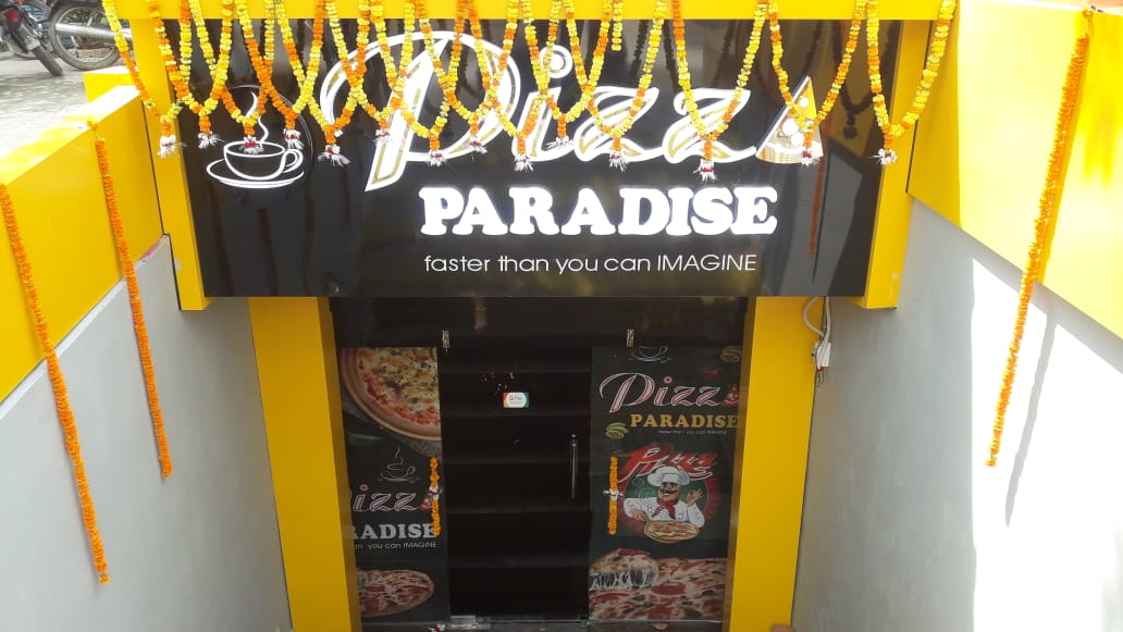 जौनपुर। बच्चों और बड़ों का फेवरेट पिज्जा अब उनके मनपसंद रेस्टोरेंट 'पिज्जा पैराडाइस (Pizza Paradise)' वाजिदपुर तिराहा पर खाने को मिलेगा क्योंकि शुक्रवार को बहुप्रतिक्षित इस पिज्जा रेस्टोरेंट का भव्य उद्घाटन हो गया। कोरोना काल न होता तो बहुत पहले ही जनपदवासियों का पसंदीदा रेस्टोरेंट पहले ही खुल गया होता लेकिन लॉकडाउन की वजह से थोड़ी देर हुई। ख़ैर जौनपुर शहर में अपनी नाम को लेकर चर्चा में रहने वाले 'पिज्जा पैराडाइस (Pizza Paradise)' रेस्टोरेंट में पहले दिन ही पिज्जा खाने वालों की कतार लग गयी। रेस्टोरेंट प्रशासन ने सबसे पहले सभी को सेनेटाइज किया और सोशल डिस्टेसिंग का ध्यान रखते हुए सभी को दूर—दूर बैठाया। इनमें अधिकतर लोगों ने अपना पसंदीदा पिज्जा पैक कराया और परिवार के साथ खाने के लिए घर ले गये। प्रतिष्ठान के अधिष्ठाता शुभम सिंह एवं शिवम सिंह ने बताया कि हमारे रेस्टोरेंट पर पिज्जा की कई वेरायटी मौजूद है। काफी दिन से इस शुभ घड़ी का हम इंतजार कर रहे थे। आखिरकार वह घड़ी आ ही गयी। पहले दिन ही सैकड़ों लोगों ने पिज्जा का स्वाद चखा। उन लोगों को हमारे यहां का पिज्जा काफी पसंद आया। उनकी तारीफ सुनकर हमारी टीम और उत्साहित हो गयी। इसके पूर्व आनलाइन डिलीवरी 9519149897, 9918509194 की सुविधा शुरू की गयी थी वह भी निरन्तर चल रही है। दिन भर में सौ से अधिक डिलीवरी की जा रही है। रेस्टोरेंट पर शासन की गाइडलाइन के अनुसार ही कार्य किया जा रहा है। सबसे पहले ग्राहकों को सेनेटाइज किया जा रहा है उसके बाद ही उनके आर्डर लिये जा रहे हैं। ग्राहकों को हमारी यहां की सेवा अच्छी लगी। सबसे बड़ी बात तो यह है कि हमारे यहां की सर्विस औरों की अपेक्षा काफी अच्छी है।